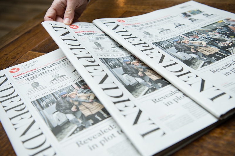A woman poses with the final print edition of the Independent newspaper in London on March 26, 2016. u00e2u20acu201d AFP pic