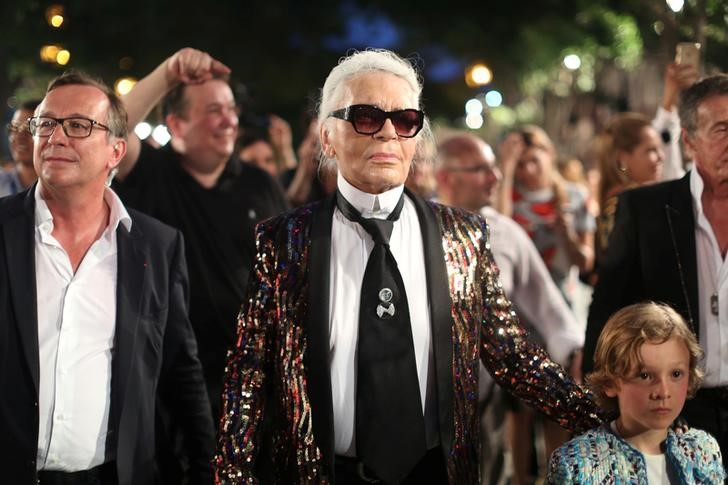 German photographer Karl Lagerfeld (centre), head designer and creative director of fashion houseChanel, walks with a model after a fashion show of his latest inter-seasonal Cruise collection, at the Paseo del Prado street in Havana, Cuba, May 3, 2016.