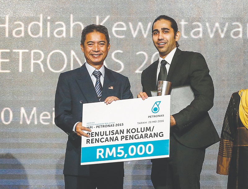 Haresh receives his award from RTM broadcast chief Datuk Abu Bakar Ab Rahim. — Picture by Firdaus Latif 