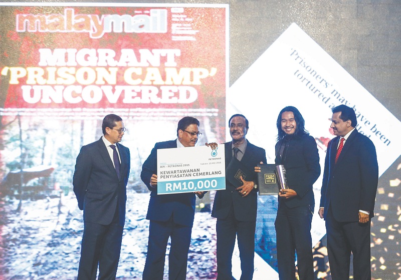 Sayuti (second from right) and Arulldas receive their award from Bernama general manager Datuk Zulkefli Salleh. u00e2u20acu201d Picture by Firdaus Latif 