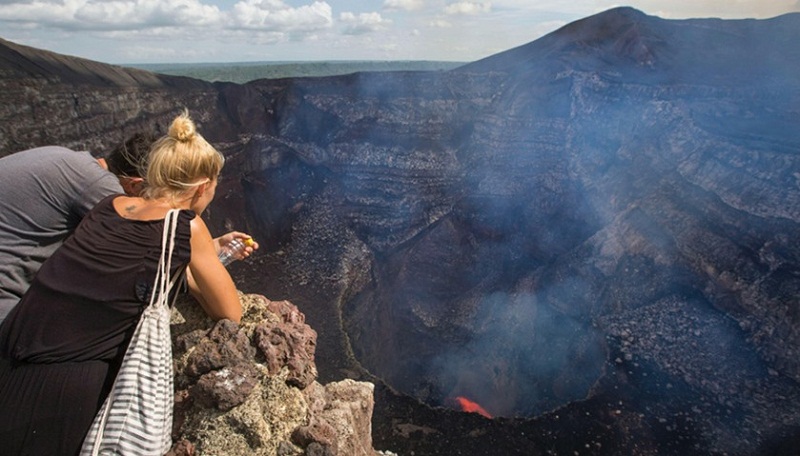 Tourists watch a lava lake inside the crater of the Masaya Volcano in Masaya, some 30km from Managua on May 19, 2016.
