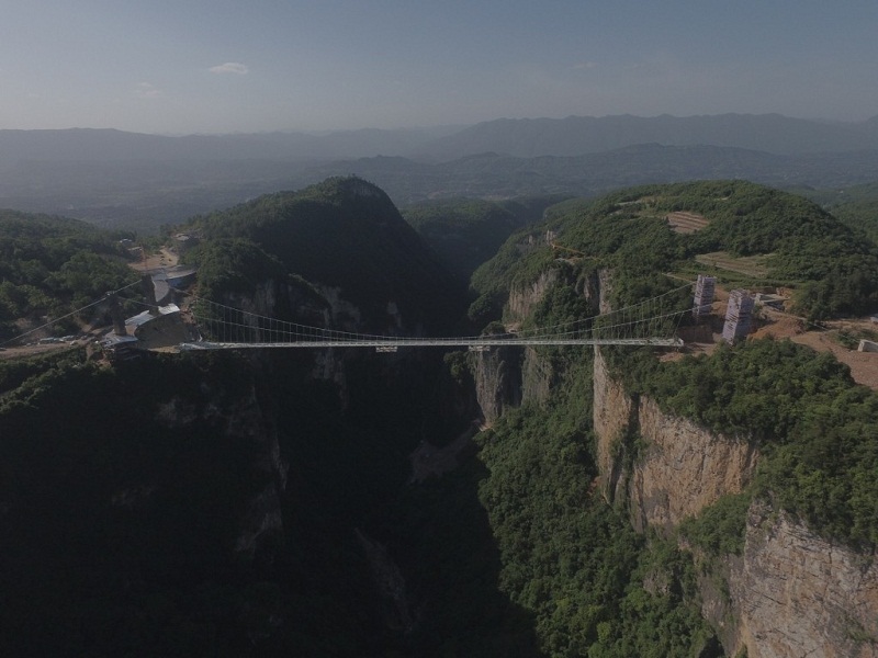 Though the Zhangjiajie Grand Canyon Glass Bridge will claim several bragging rights when it opens, the one title it won’t hold is being China’s first glass bridge. 