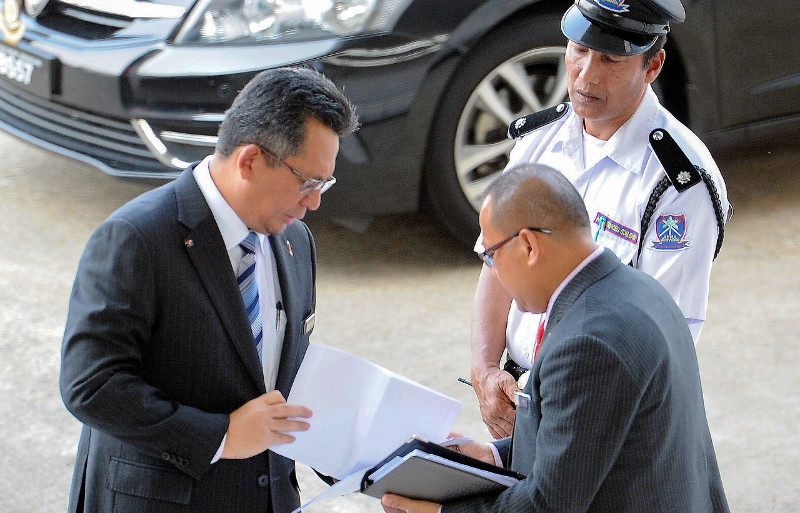 Terengganu Menteri Besar Ahmad Razif Abdul Rahman (left) examining a document on arrival at Wisma Darul Iman to chair the state executive council meeting on April 27, 2016. u00e2u20acu201d Bernama pic