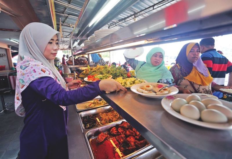Syatirah arranges food at her restaurant in Lembah, Kuala Kangsar. She expects more people to frequent her restaurant during the election period. nu00e2u20acu201d Picture by Farhan Najib