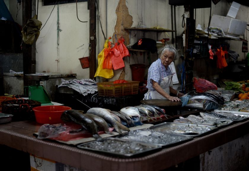 An old Malaysian woman waits for customers at a wet-market in downtown Kuala Lumpur on May 14, 2016. u00e2u20acu201d AFP pic
