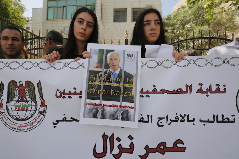 Palestinian journalists hold placards and banners during a demonstration on April 24, 2016 in support of their colleague, Omar Nazzal.u00c2u00a0u00e2u20acu201d AFP pic