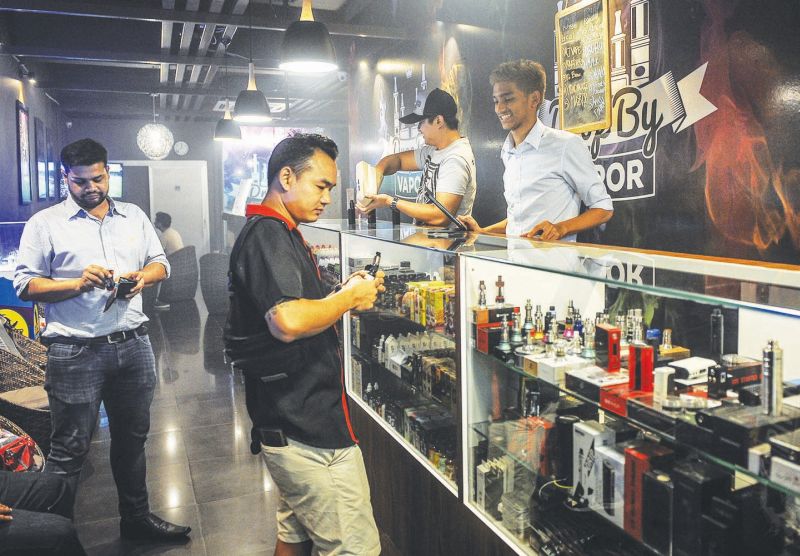 Ibnu Ridha, 28, (wearing cap) and Hazique Riefdi, 20, behind the counter at u00e2u20acu02dcDrop by Vaporu00e2u20acu2122 in Damansara Utama Uptown.u00e2u20acu201d Picture by Firdaus Latif