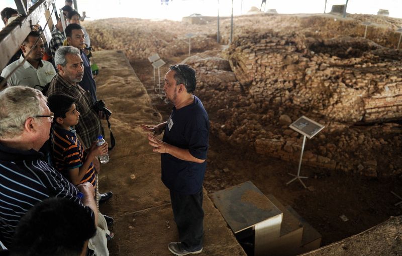 Universiti Sains Malaysia’s Director of Centre for Global Archaeological Research, Professor Datuk Dr Mokhtar Saidin (right) takes participants on a guided tour around the Sungai Batu ancient site.