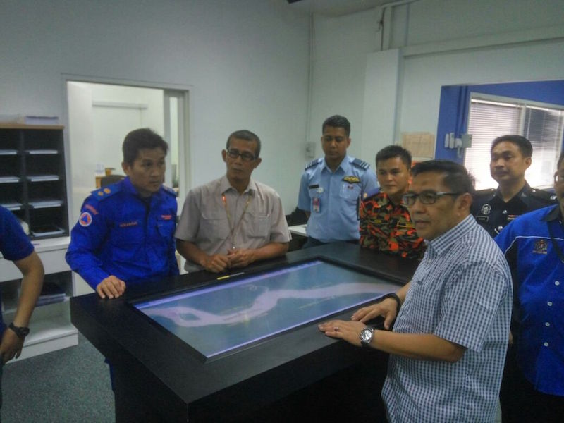 DCA’s Azharuddin (in blue, wearing glasses) at the command centre for the search and rescue mission at Kuching International Airport May 8, 2016. — Picture by Kenneth Tee