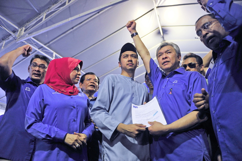 Datuk Seri Dr Ahmad Zahid Hamidi hands the nomination papers to Wan Emir Astar Wan Mohamad Khair-il (centre), who is representing his moher Datin Mastura Mohd Yazid in Kuala Kangsar May 28, 2016. u00e2u20acu201d Bernama pic