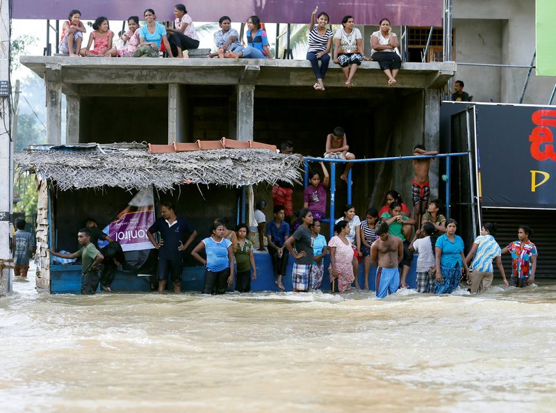 People sit atop a roof of a house on a side of a flooded road in Biyagama, Sri Lanka May 20, 2016. u00e2u20acu201d Reuters pic