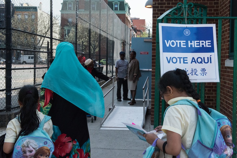 A woman with a Muslim headscarf walks past a voting sign at PS 3 on April 19, 2016 in the Brooklyn borough of New York City. u00e2u20acu201d AFP pic