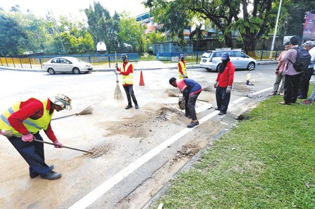 DBKL workers cleaning up at Jalan Pantai Baharu after flash floods on May 12. u00e2u20acu201d Picture by Firdaus Latif