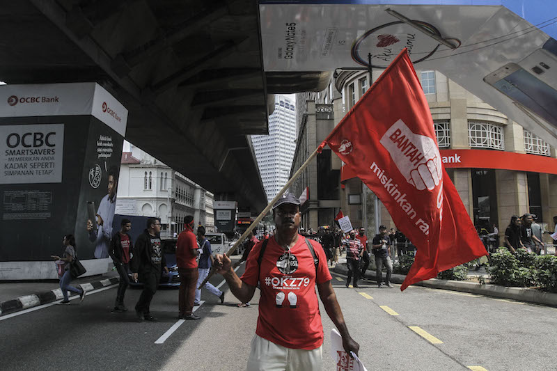 A participant holds a flag as he marches during a rally held in conjunction with Labour Day in Kuala Lumpur May 1, 2016. u00e2u20acu201d Picture by Yusof Mat Isa