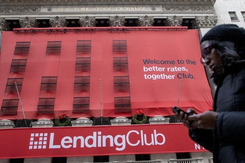 A woman looks at her phone as she passes by a Lending Club banner on the facade of the the New York Stock Exchange December 11, 2014. u00e2u20acu201d Reuters pic
