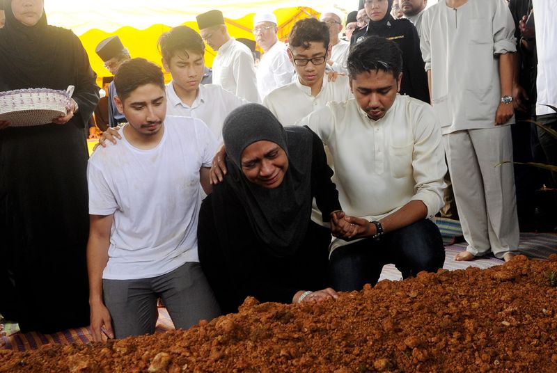 Datin Mastura Mohd Yazid ditenangkan anak-anaknya apabila tidak dapat menahan sebak ketika pengkebumian suaminya Datuk Wan Khair-il Anuar Wan Ahmad di makam diraja Kuala Kangsar di Bukit Chandan. u00e2u20acu201d Foto Bernama 