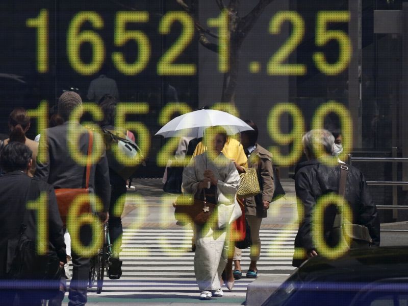 A woman clad in a kimono is reflected in an electronic board displaying Japan's Nikkei share average outside a brokerage in Tokyo, Japan, April 18, 2016. u00e2u20acu2022 Reuters pic 
