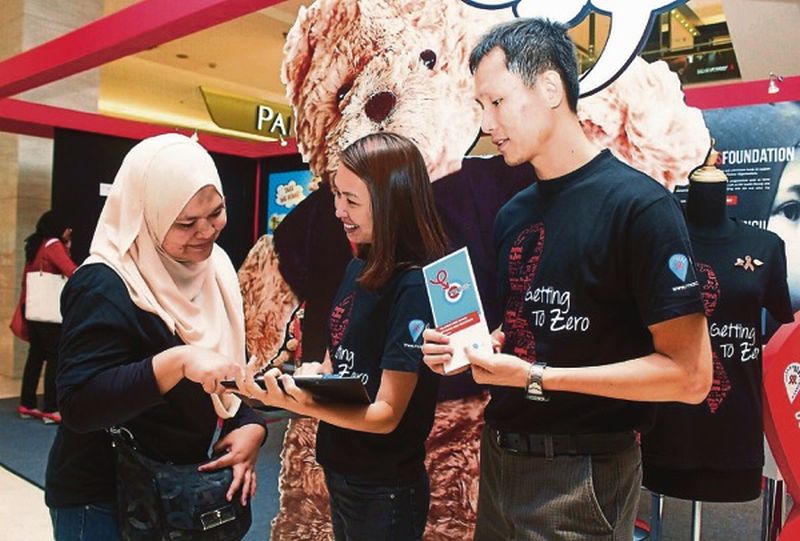 A visitor takes part in a HIV knowledge survey conducted by volunteers at the Red Ribbon Popup Store. u00e2u20acu201d Picture courtesy of Malaysian AIDS Council