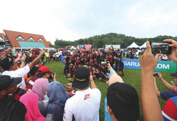 Fans rush to take photographs of the national team after the match against Singapore on Saturday. u00e2u20acu201d Picture by Zuraneeza Zulkifli