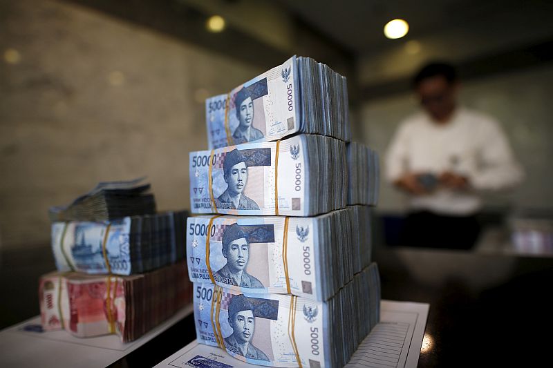 A teller in Bank Indonesiau00e2u20acu2122s headquarters counts rupiah bank notes in Jakarta April 21, 2016. u00e2u20acu201d Reuters pic