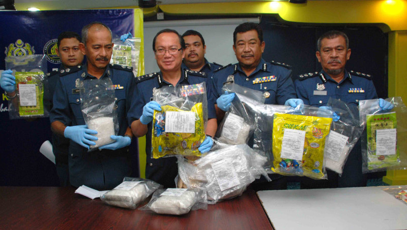 Sabah Customs Department director Datuk Janathan Kandok (front, second left) showing the seized syabu and the packets they had been hidden in, during a press conference in Kota Kinabalu May 25, 2016. u00e2u20acu201d Picture by Julia Chan