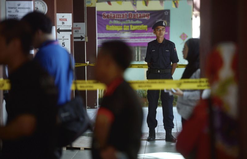 A police officer on duty at a polling centre in Kuching, May 7, 2016. u00e2u20acu2022 Bernama pic