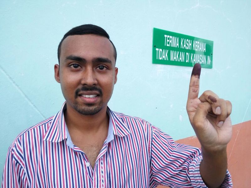 Yogeswara Barathi, 27, pictured outside the polling centre of SRB Garland, shows his inked finger indicating that he has cast his vote. u00e2u20acu2022 Picture by Azdee Amir