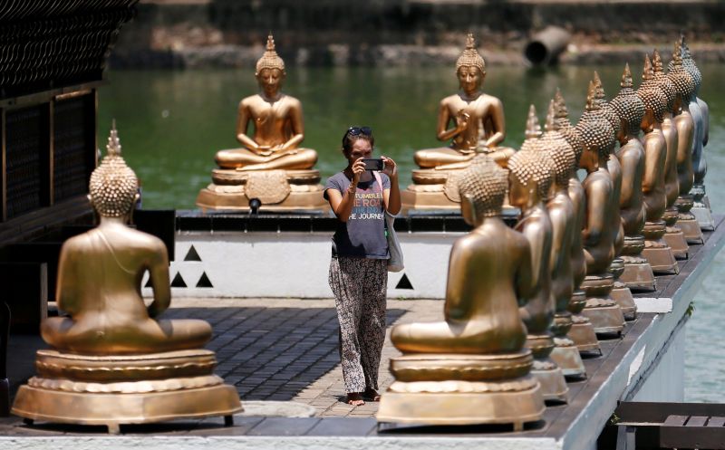 A tourist takes pictures of Buddha statues at a temple in Colombo, Sri Lanka May 7, 2016. u00e2u20acu2022 Reuters pic