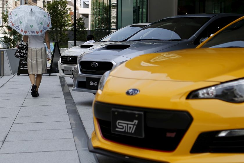 A woman holding an umbrella walks past Fuji Heavy Industries Ltd (FHI)'s Subaru cars displayed outside a showroom at the company's headquarters in Tokyo, Japan, in this picture released May 9, 2016. u00e2u20acu201d Reuters pic