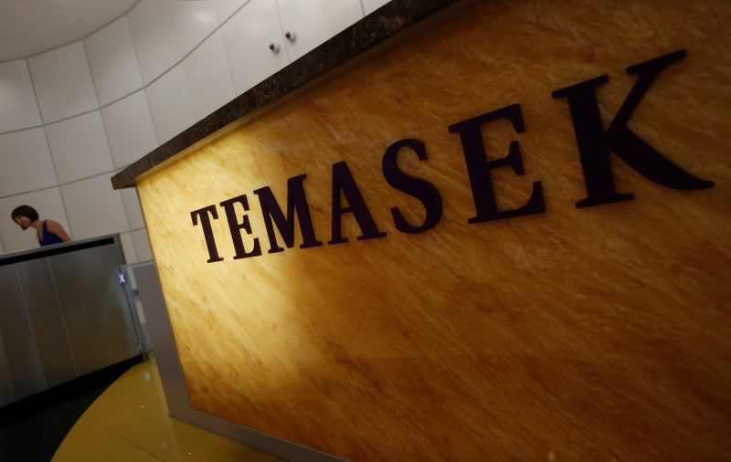 A woman passes a logo of state investor Temasek Holdings at their office in Singapore July 8, 2014. u00e2u20acu201d Reuters pic