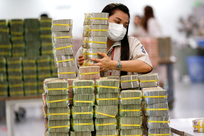 A bank employee gathers Thai baht notes at a Kasikornbank in Bangkok, Thailand. u00e2u20acu2022 Reuters pic