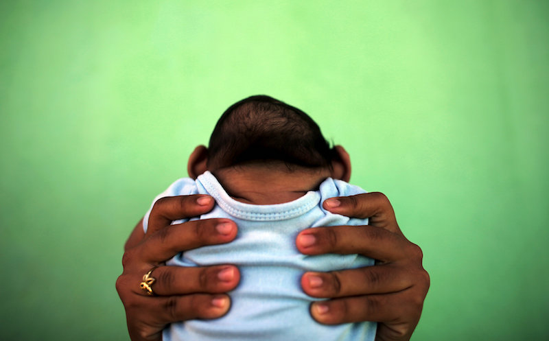 A four-month-old baby born with microcephaly is held by his mother in front of their house in Olinda, near Recife, Brazil, February 11, 2016. u00e2u20acu201d Reuters pic