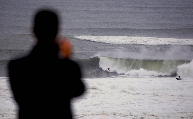 A spectator watches a surfer as he rides a large wave after being pulled onto it by a jet ski near Long Reef beach in Sydney June 6, 2016. u00e2u20acu201d Reuters pic