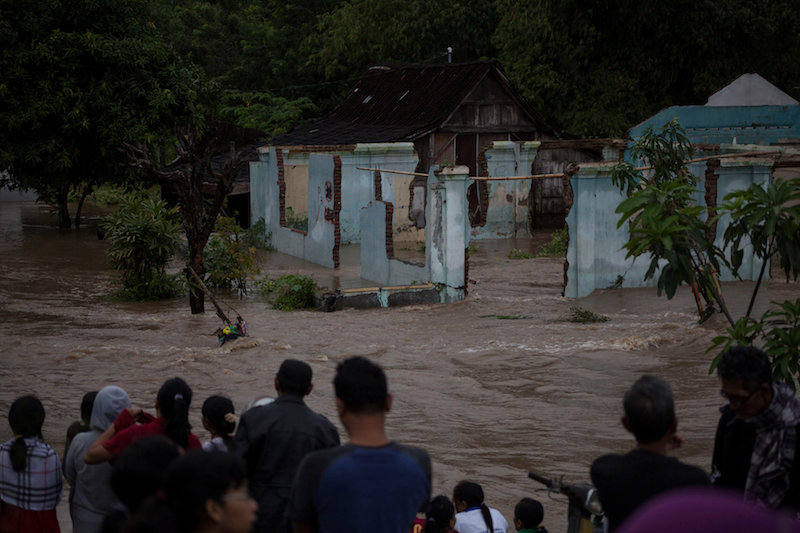 People stand in front of a flooded area in Kampung Sewuresidential area in Solo, Central Java province, Indonesia, June 19, 2016. u00e2u20acu201d Reuters pic