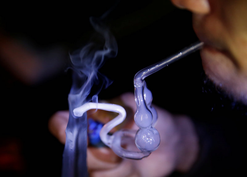 A drug addict uses a glass water pipe to smoke syabu, or methamphetamine, at an undisclosed drug den in Manila June 20, 2016. u00e2u20acu201d Reuters pic
