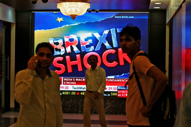 People stand past a screen displaying news of markets update inside the Bombay Stock Exchange (BSE) building in Mumbai June 24, 2016. u00e2u20acu201d Reuters pic