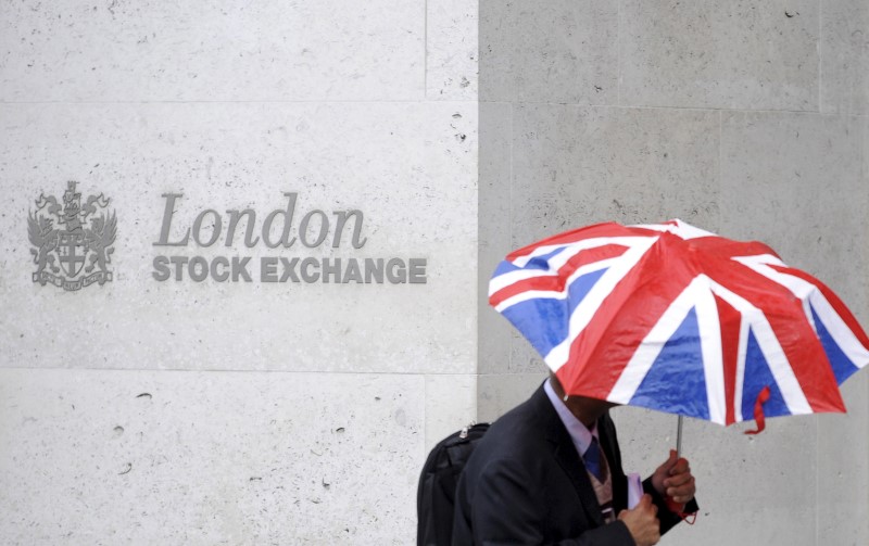 A worker shelters from the rain as he passes the London Stock Exchange in the City of London at lunchtime October 1, 2008. u00e2u20acu201d Reuters pic
