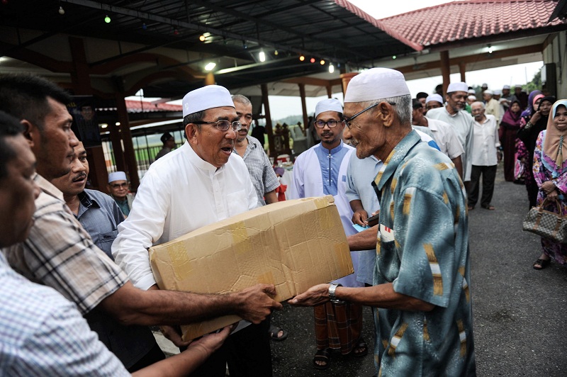Timbalan Menteri Pertahanan Datuk Mohd Johari Baharom (kiri) menyampaikan sumbangan kepada seramai 200 penduduk pada Majlis Berbuka Puasa di Masjid Kampung Darat, Changlun pada 28 Jun, 2016. u00e2u20acu201d Foto Bernama