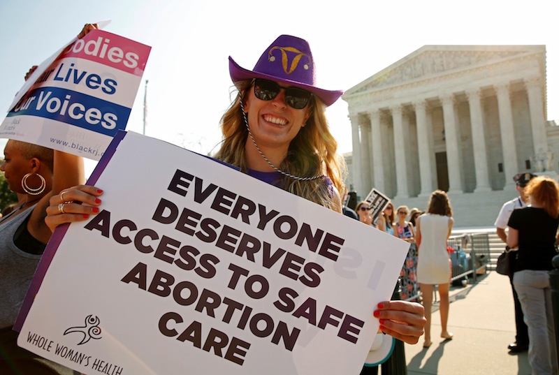 A demonstrator wearing a cowboy hat with a uterus symbol holds a sign outside the US Supreme Court in Washington, US June 27, 2016. u00e2u20acu201d Reuters pic