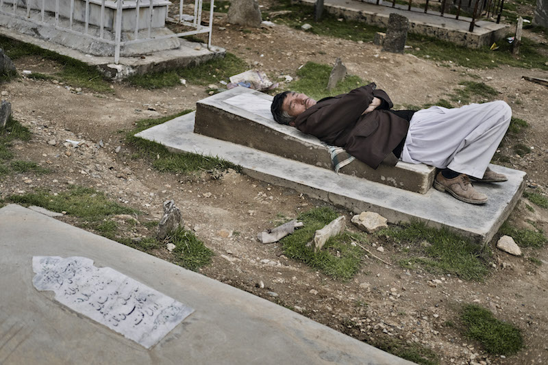 An Afghan man rests on a gravestone at Kart-e-Sakhi cemetery in Kabul, Afghanistan, March 20, 2016. — Picture by Adam Ferguson/The New York Times