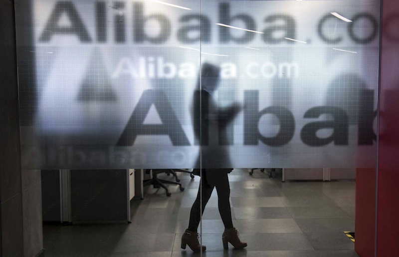 An employee is seen behind a glass wall with the logo of Alibaba at the company's headquarters on the outskirts of Hangzhou, Zhejiang province, April 23, 2014. u00e2u20acu201d Reuters pic