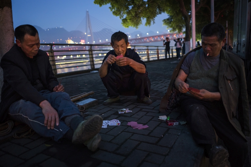 Porters, collectively known as ‘bang-bang’, playing cards while waiting for work at the docks on the banks of the Yangtze River in Chongqing, China, April 3, 2016. — Picture by Adam Dean/The New York Times