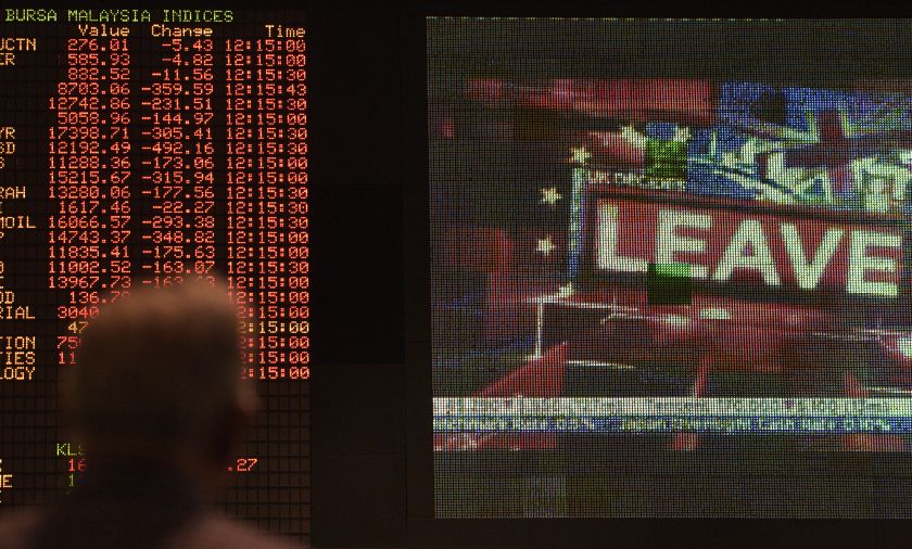 A trader watches electronic boards showing stock movements at the Malaysia Stock Exchange in Kuala Lumpur on June 25, 2016. u00e2u20acu201d AFP pic