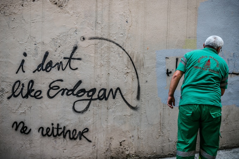 A  municipal worker covers grafities on a wall with grey paint before a demonstration near the Pro Kurdish 'Ozgur Gundem' newspaper`s headquarter on June 21, 2016 in Istanbul. u00e2u20acu201d AFP pic