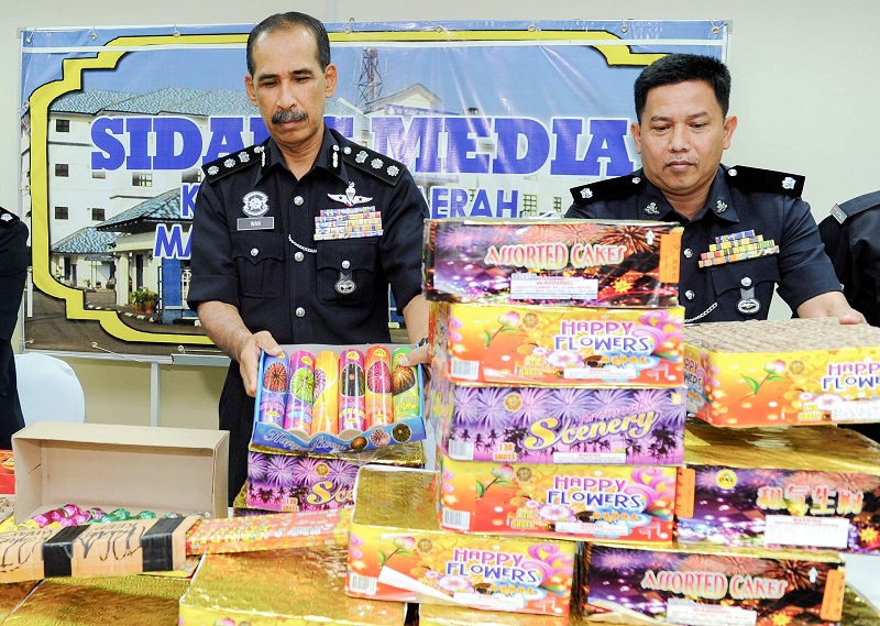 State Criminal Investigations Department chief ACP Wan Abd Aziz Wan Hamzah (left) inspects the firecrackers worth RM10,000 which were confiscated during a raid at Kampung Bukit Gasing, in Marang June 21, 2016. u00e2u20acu201d Bernama pic