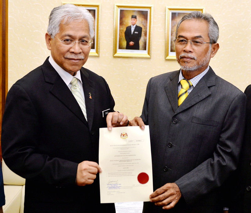 Higher Education Minister Datuk Seri Idris Jusoh (left) hands over a letter of granting full university status for KUISAS to become Universiti Sultan Azlan Shah, to its president Tan Sri Dr Nordin Kardi, June 14, 2016 in Kuala Kangsar. u00e2u20acu201d Bernama pic