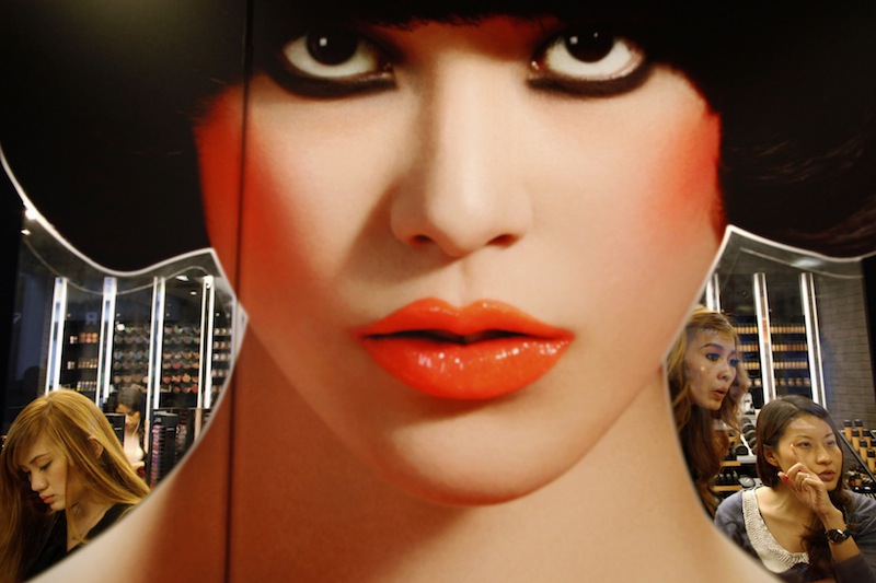 A sales assistant (right) applies makeup on a customer at a cosmetics counter at a shopping mall in Singapore June 7, 2013. u00e2u20acu201d Reuters pic