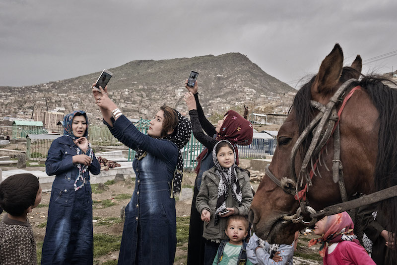 Women photograph themselves while picnicking at Karte-e-Sakhi cemetery in Kabul, Afghanistan, April 8, 2016. — Picture by Adam Ferguson/The New York Times