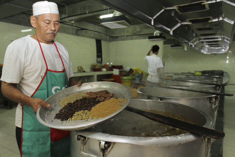 Head cook Zainal Abidin Abdul Hamed shows some of the essential spices that go into ‘bubur lambuk.’