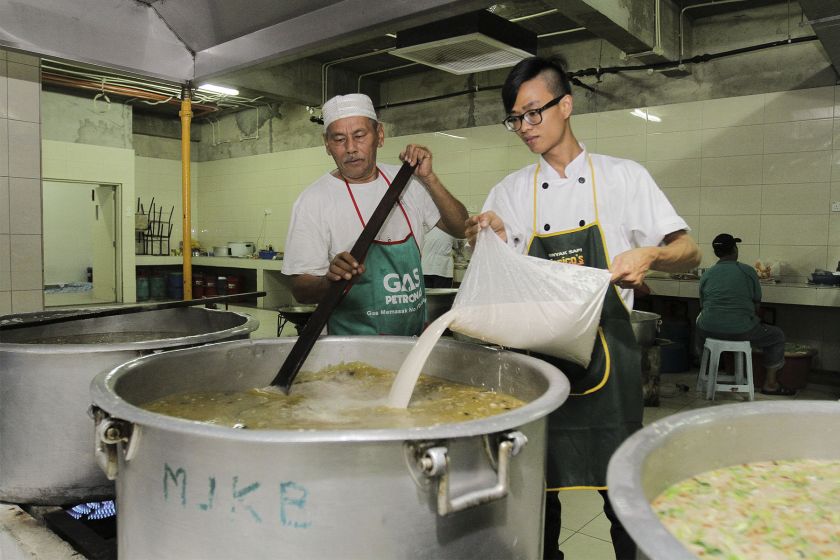 Head cook Zainal Abidin Abdul Hamed, 61, cooking the 'bubur lambuk' with the help of one of his staff. u00e2u20acu201d Picture by Yusof Mat Isa